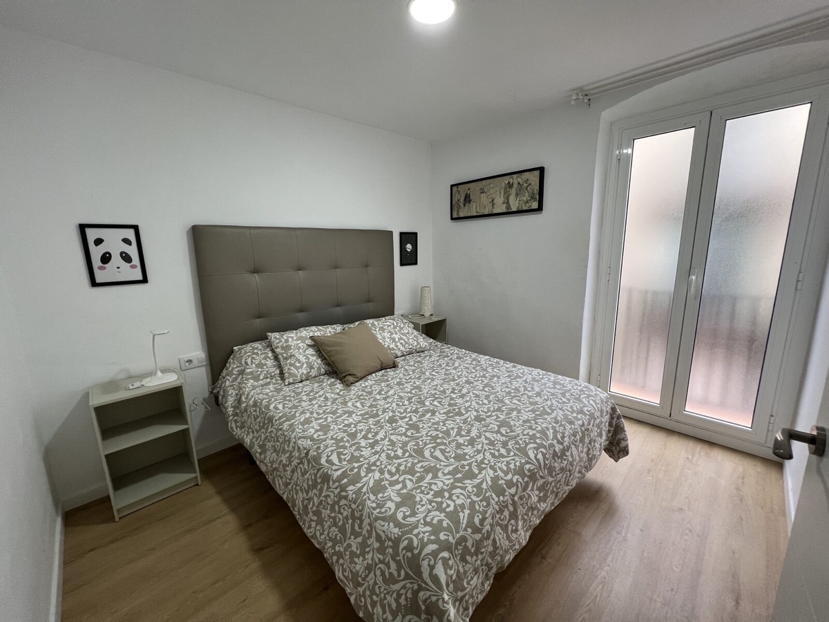 Bedroom with upholstered headboard and balcony door